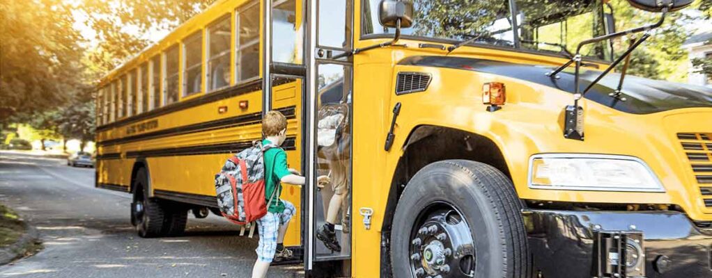 young child getting onto a school bus