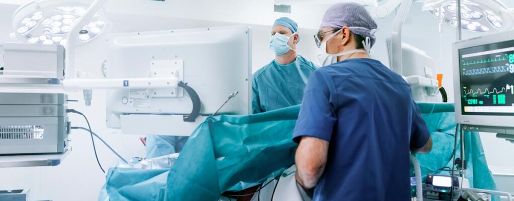 Doctors in blue scrubs work on a patient in an operating room