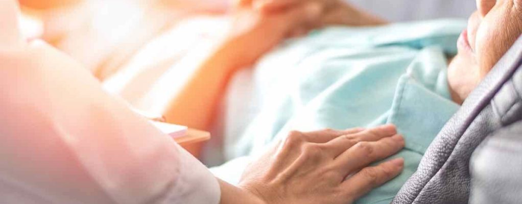 Doctor with hands on elderly patient