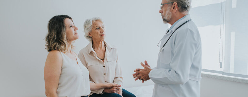 A doctor speaks with an elderly patient and her family member