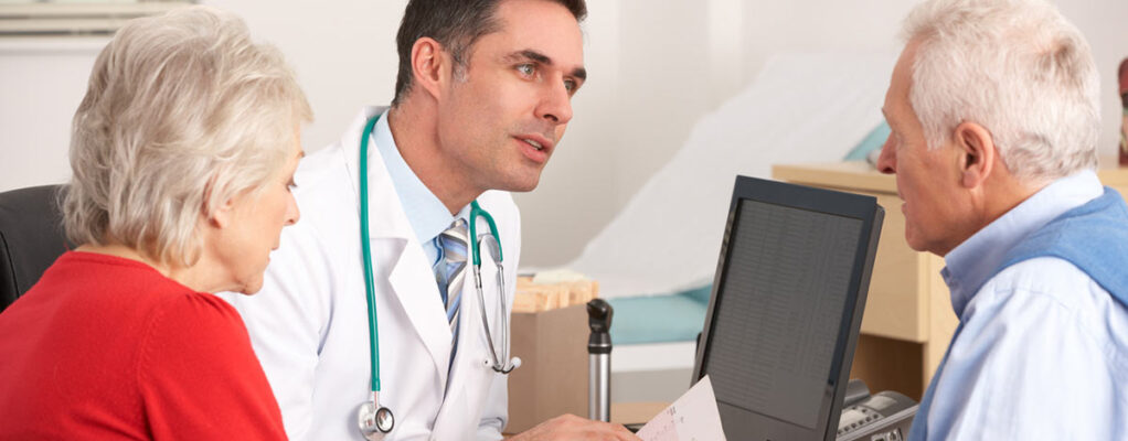Mesothelioma doctor talking to an older male patient and his wife