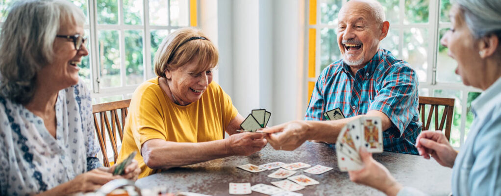 Group of people play cards together and laugh